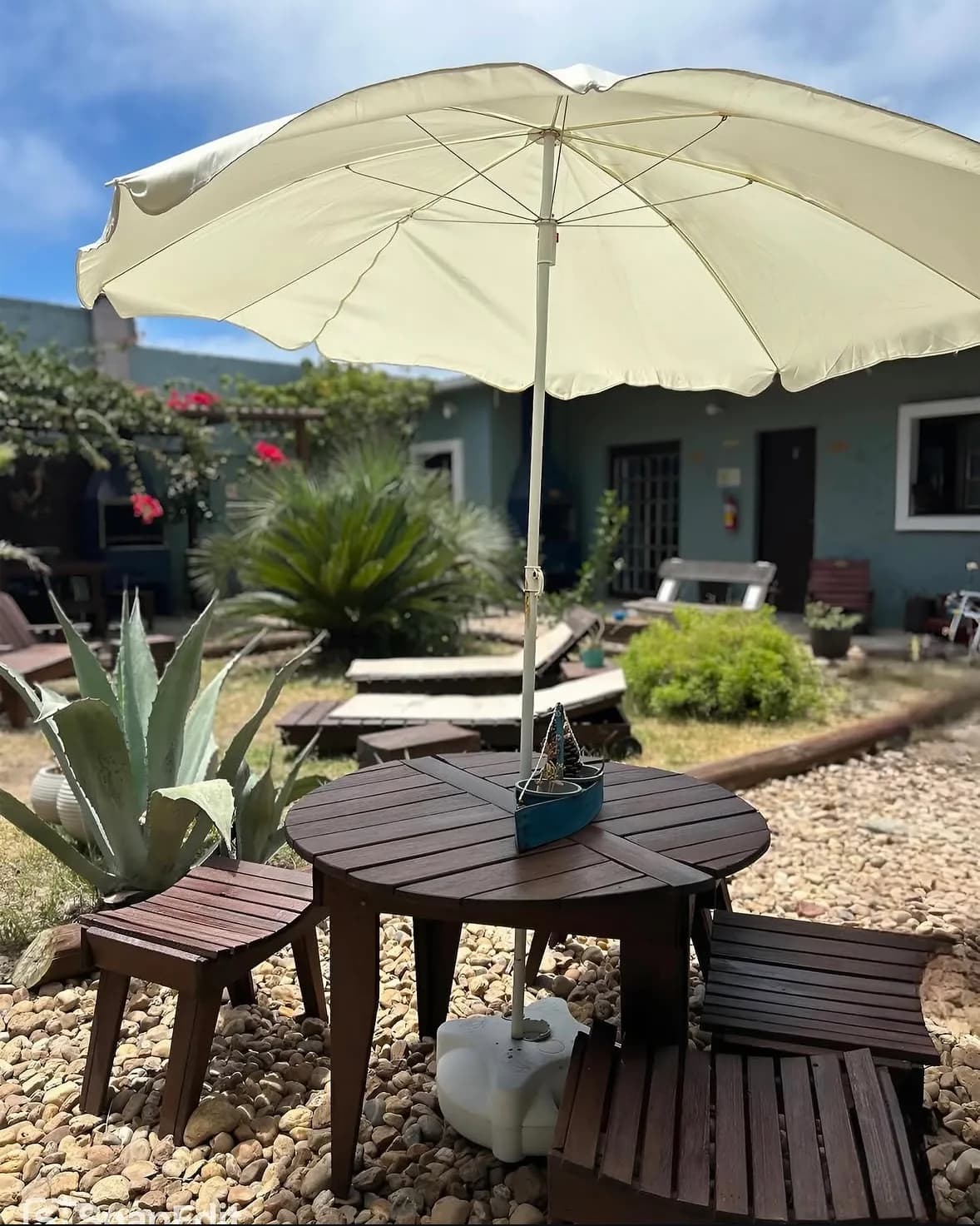Mesa com guarda-sol e espreguiçadeiras no jardim